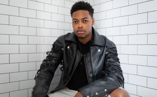 Serious portrait of a young black man with a black leather jacket