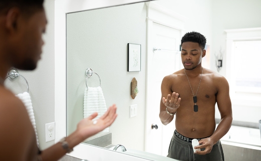 Man near bathroom mirror taking medication