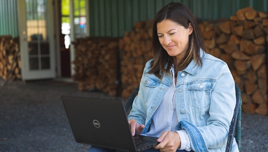 Middle-aged white woman outside on her laptop