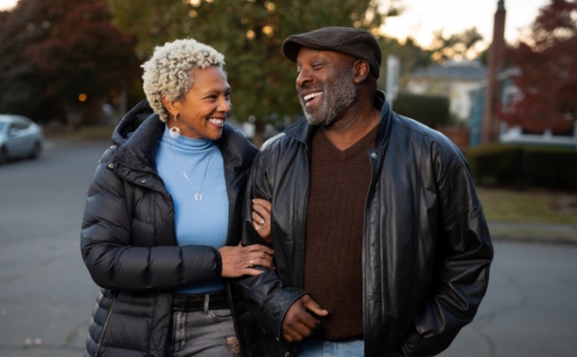 senior black couple walking down a residential street