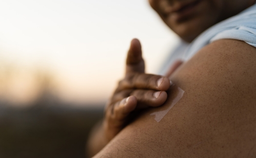 Placing a nicotine patch on an arm