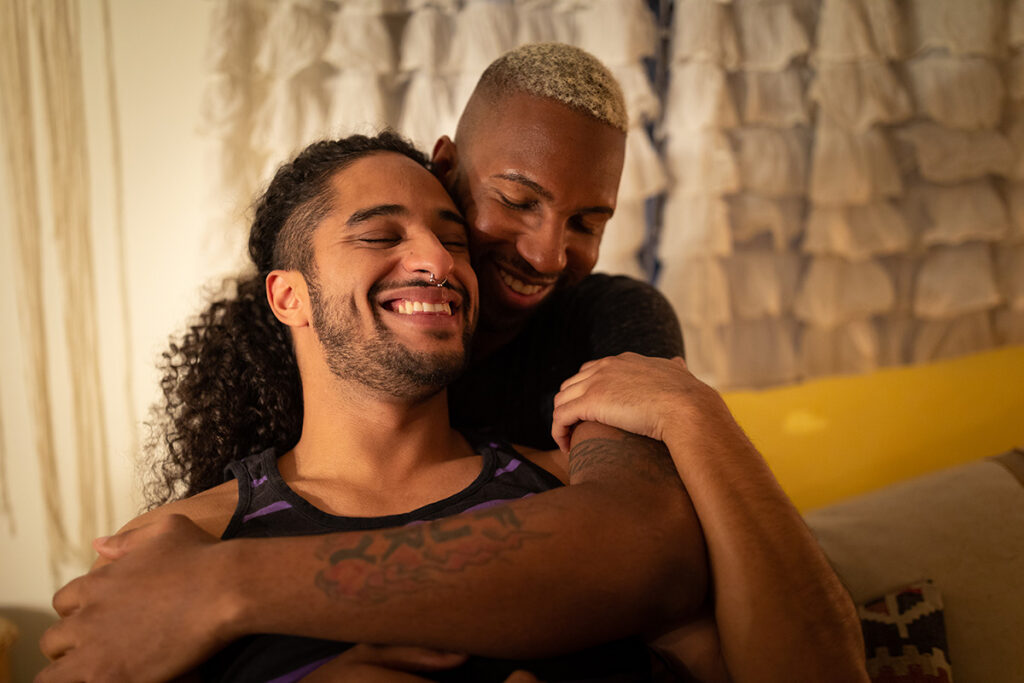 Two men in their 20's hugging
